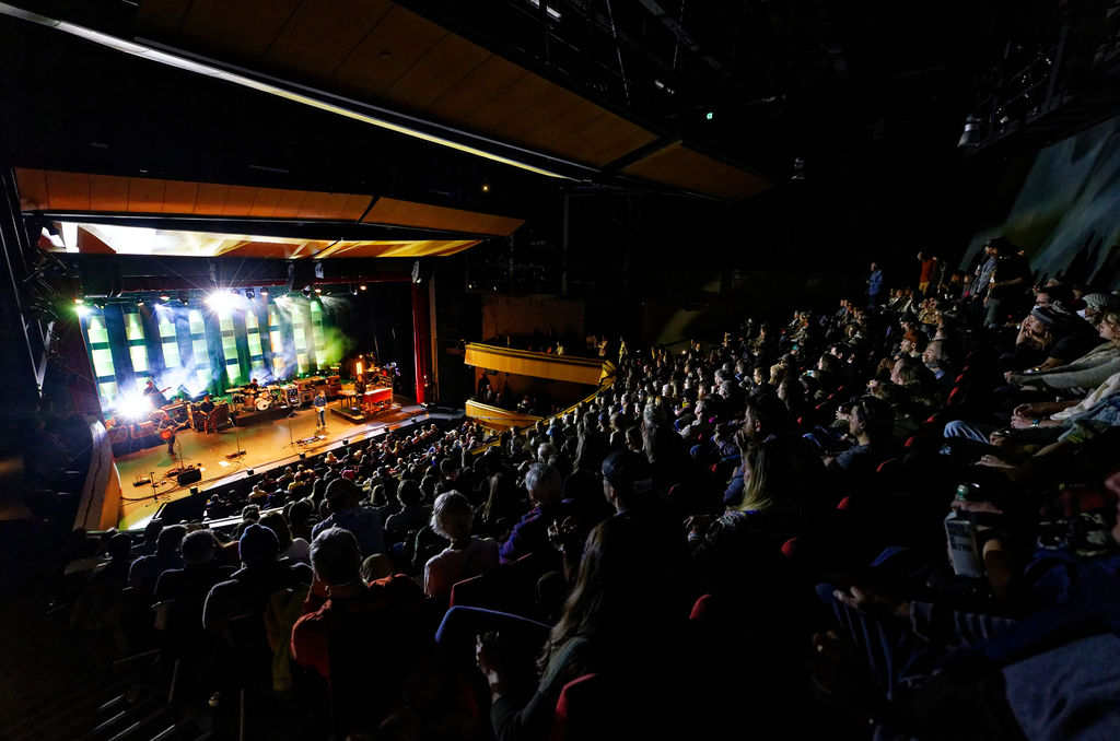 A view from the back of the theater showing a full crowd watching a performance