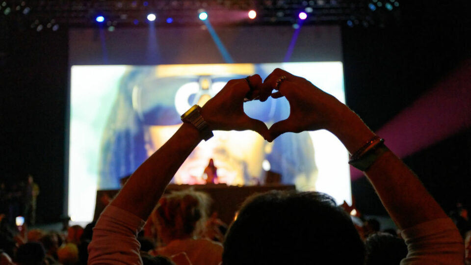 Audience member creating heart shape with hands during Steve Aoki DJ set at The Center Theater in Jackson, Wyoming