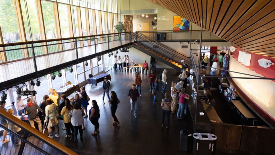 People in the auditorium buying drinks and wandering around
