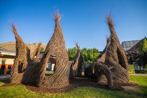 Exterior of the JH Center, with wooden sculptures shaped like tepees
