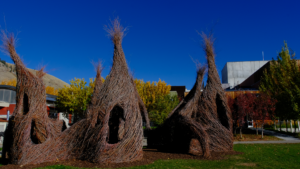 Patrick Doherty exhibit outside the Center, wooden structures in the shape of a tepee with windows cut out