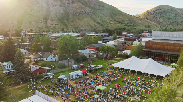 Aerial view of crowd, stage, tent and food trucks at The Center Park large outdoor Jackson Hole event venue
