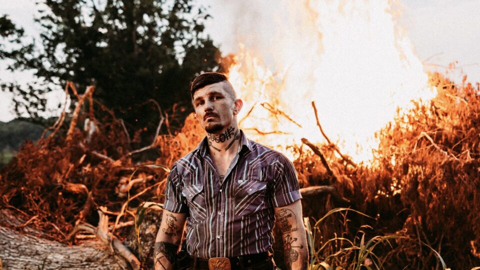 Photograph of Benjamin Tod in front of a fire in Jackson WY